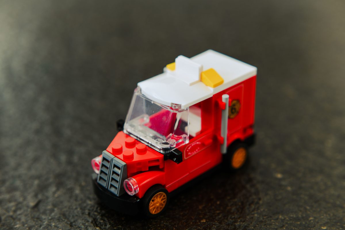 Een klein rood bestelwagentje, gebouwd van LEGO-steentjes